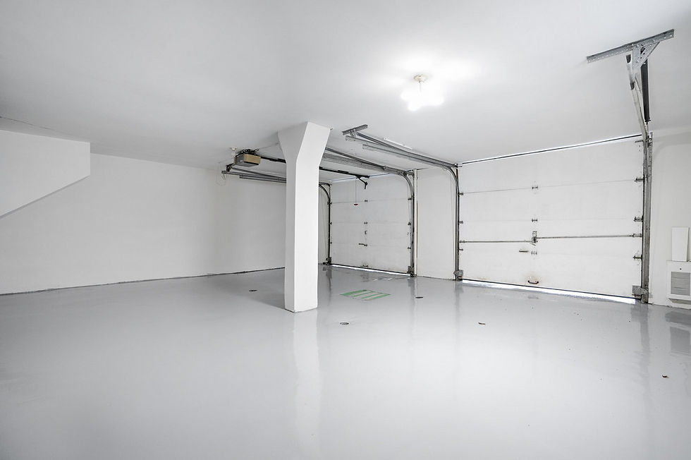 Spacious, clean, and bright two-car garage in LaSalle, Montreal, with white walls, polished epoxy flooring, two large garage doors, and a central support column under ceiling lighting.