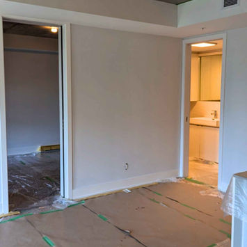 Griffintown Montreal condo interior painting in progress with walls freshly painted and protective floor covering by Maple Wood Painting.