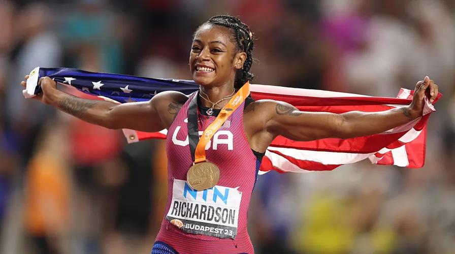 Sha'Carri Richardson with the American flag after winning the 100 meters at the World Championships and breaking a record