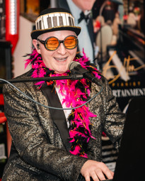 a man playing piano dressed as elton john john tribute artist