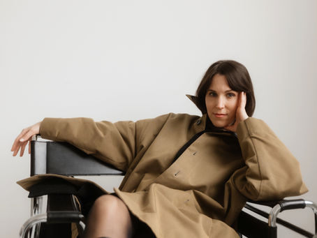 Frau auf einem Marcel Breuer Sessel in Mantel und Stiefel