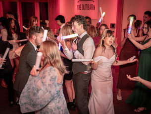 Wedding guests partying at the out Barn with their glow sticks and a jam packed dance floor