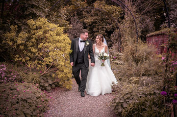Bride and groom walking hand in hand at Rowton Hall in Chester, captured in a relaxed and documentary wedding photography style