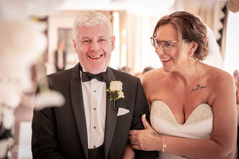 Bride Lisa and groom Carl laughing together at the front of their wedding ceremony at Bartle Hall, Preston