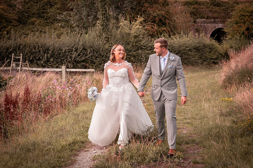 Bride and groom walking hand in hand at the Barn at Yew Tree Farm in Liverpool
