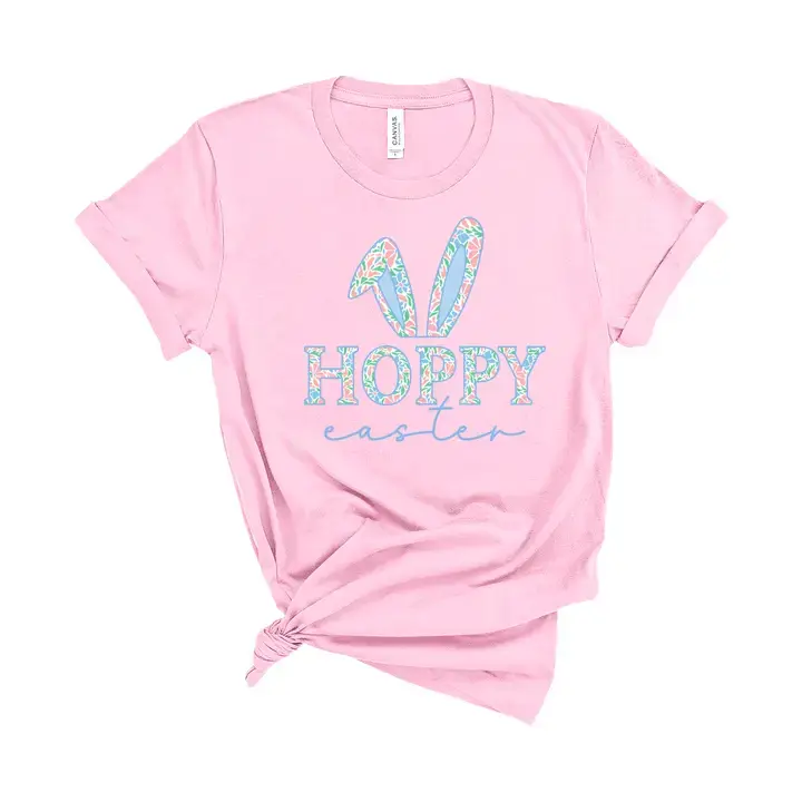 Pink tee with bunny ears in floral pastel design with text "hoppy easter below"