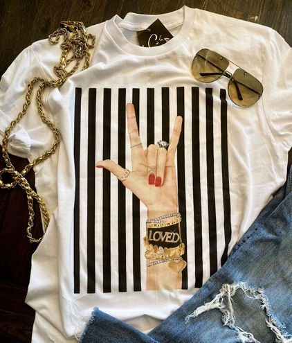 black and white striped background with arm showing heart bracelets