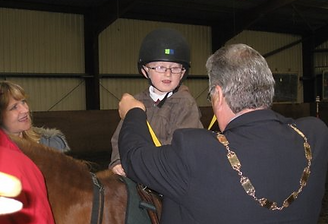 Photo of mayor giving award to young rider