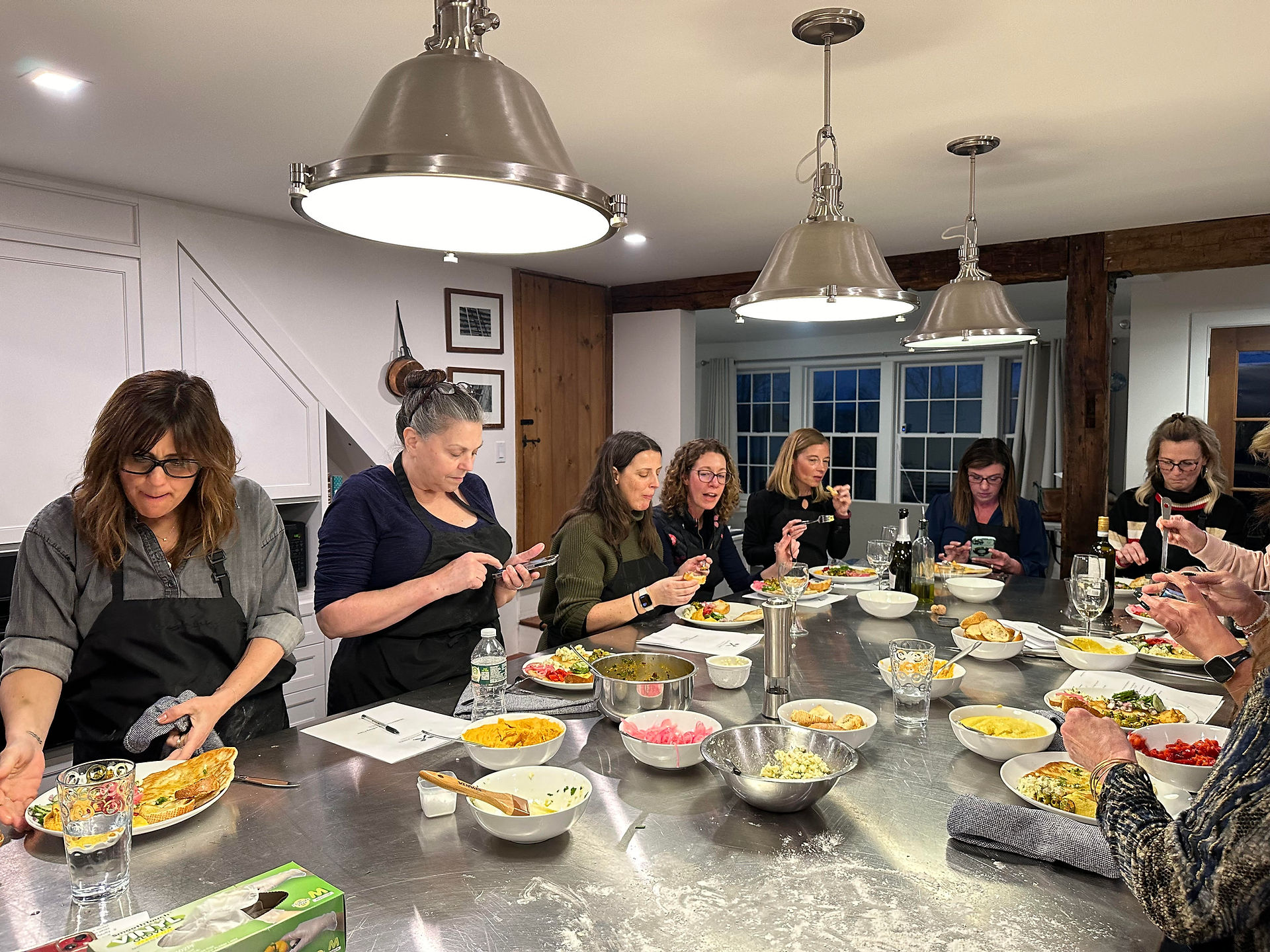 people cooking around an island at a cooking workshop