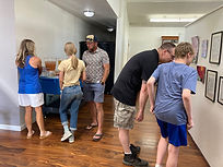 A father and son lean in to look closer at a black and white drawing.
