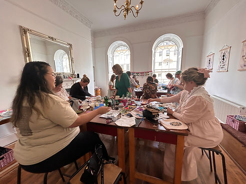 A wide angle view of many people taking part in a creative workshop held by Make Creative Studio as part of the Jane Austen festival in Bath