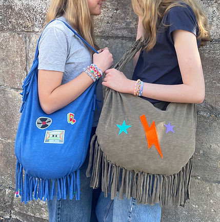 Two teen girls modelling upcycled bags and bracelets