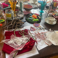 A selection of threads, sequins, fabric and vintage haberdashery laid out on a table for a creative workshop