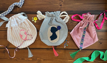 Three handmade drawstring reticules lying side by side on a wooden table, made during a Jane Austen inspired creative workshop by Make Creative Studioin Bath