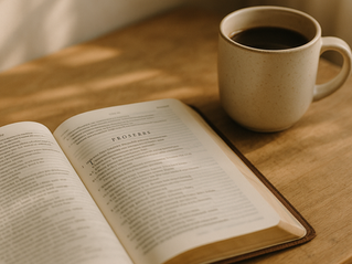 A warm, softly lit scene featuring an open Bible on a wooden desk with a ceramic coffee mug beside it. Morning sunlight casts gentle shadows across the pages, creating a peaceful and reflective atmosphere.