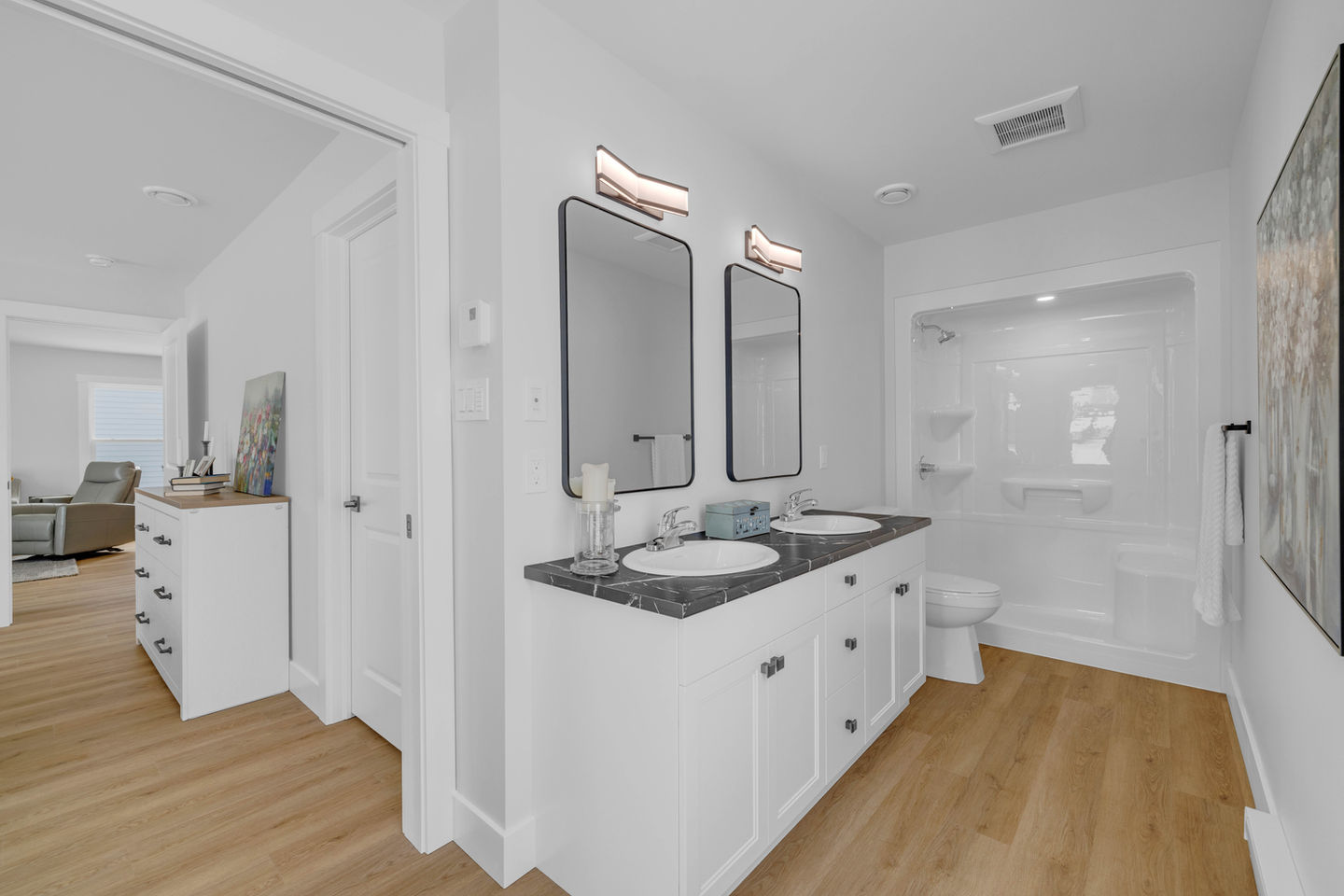 Modern bathroom with double vanity, black framed mirrors, and walk-in shower
