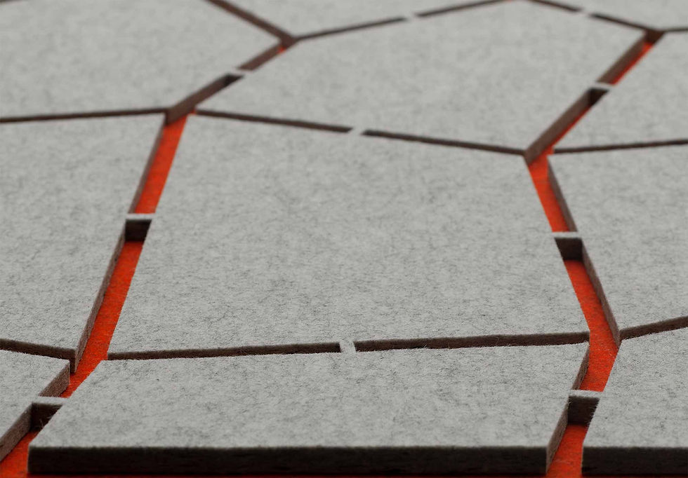 Grey, irregularly shaped felt panels on an orange surface, geometric pattern.