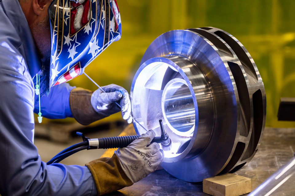 A worker inspects and fine-tunes a piece of equipment.