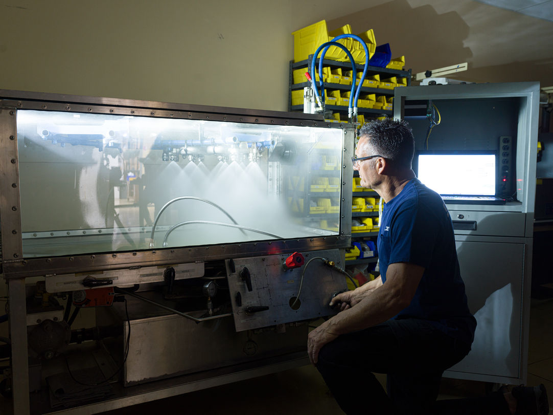 An engineer cleaning and testing an industrial manufacturer's product.