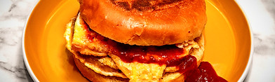 Our Shami Anda Burger is a desi street food classic — tender shami kebab, a fried egg, and chutneys packed into a soft bun. A