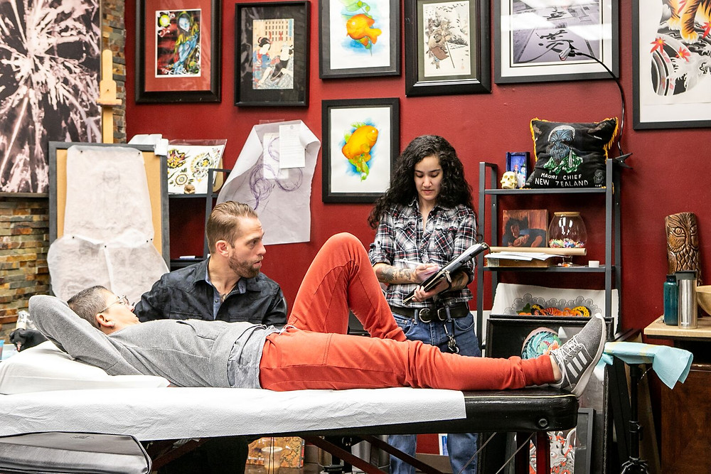 Senior artist Mikey Vigilante helps apprentice Jackie Siu with a tattoo design.