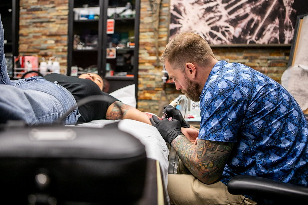 Tattoo coverup expert Mikey Vigilante tattooing a client in Long Beach.