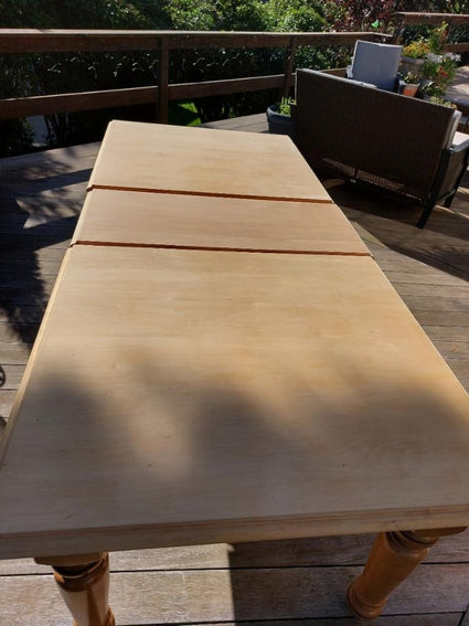 The process of stripping an old antique dining table. 