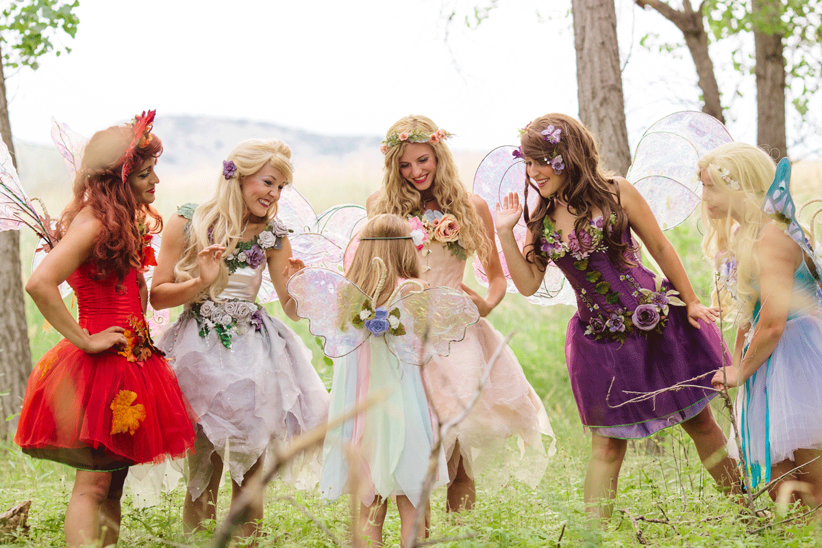 Four fairies at an outdoor fairy party with little girl in fairy wings