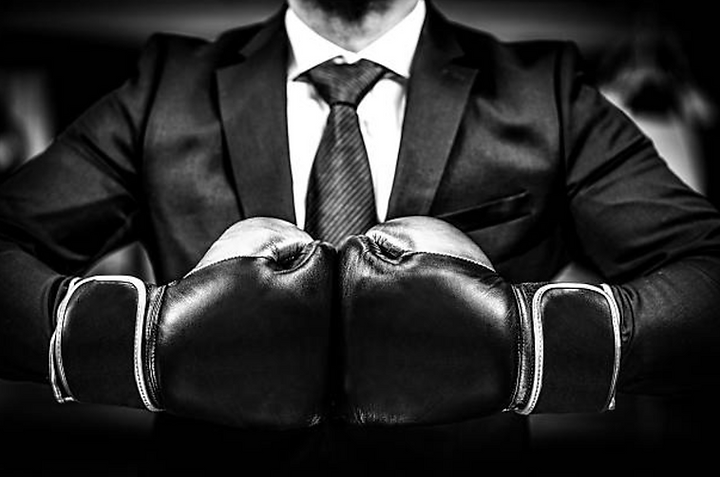 man in suit wearing boxing gloves