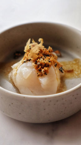 Sashimi van coquille met een yuzu-miso dressing en gefrituurde uitjes