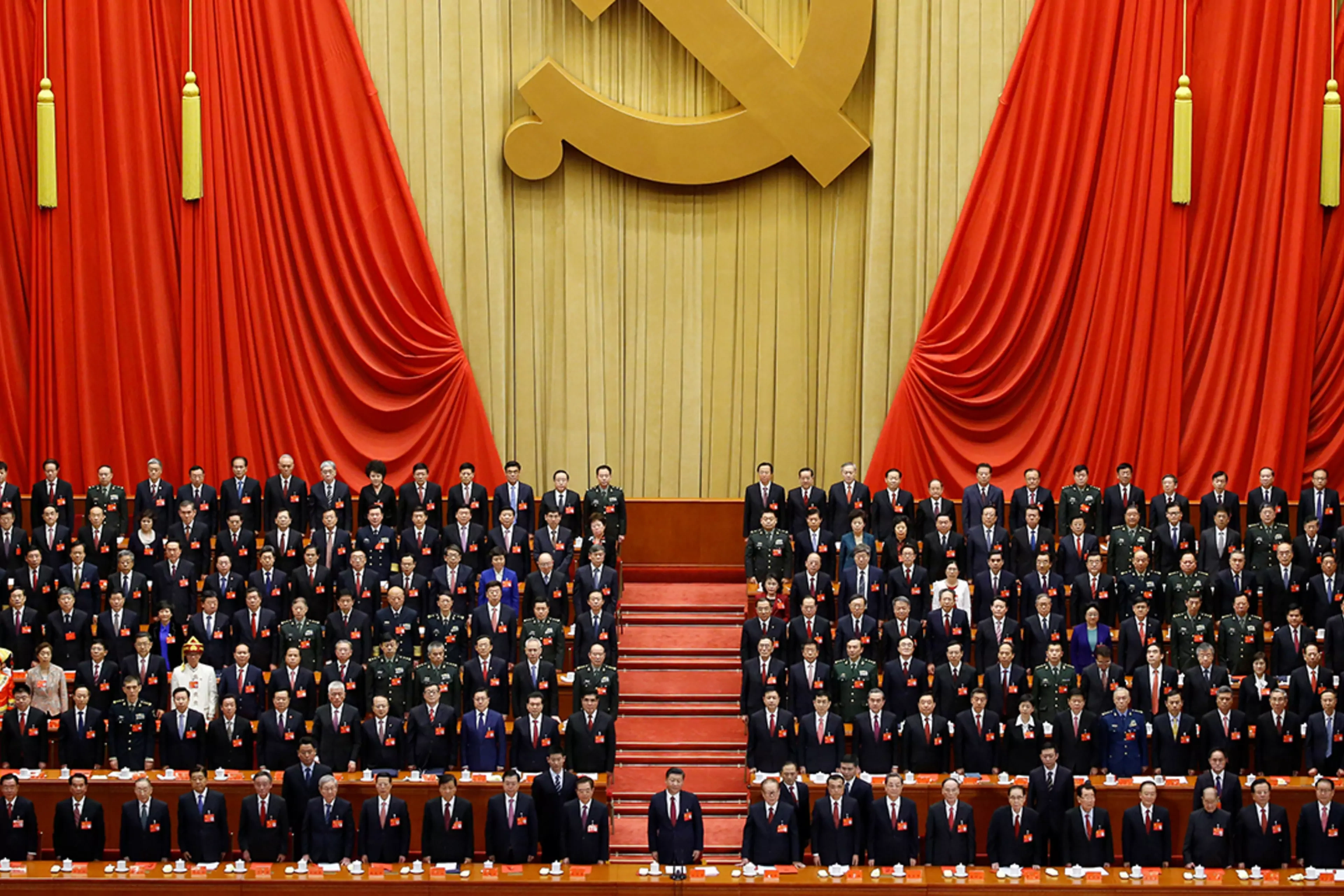 Xi Jinping stands before delegates