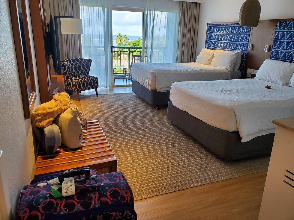 A balcony room with two queen size beds at the OUTRIGGER Fiji Beach Resort