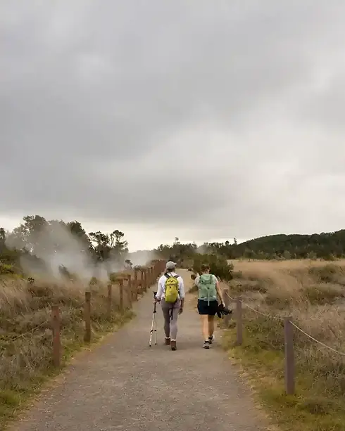 Two hikers walking near steam vents in Hawaiʻi Volcanoes National Park