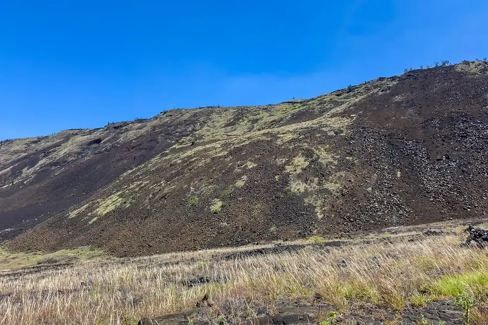 The steep slopes of Hilina Pali reveal layers of volcanic rock and loose lava, making the descent as challenging as it is rewarding.