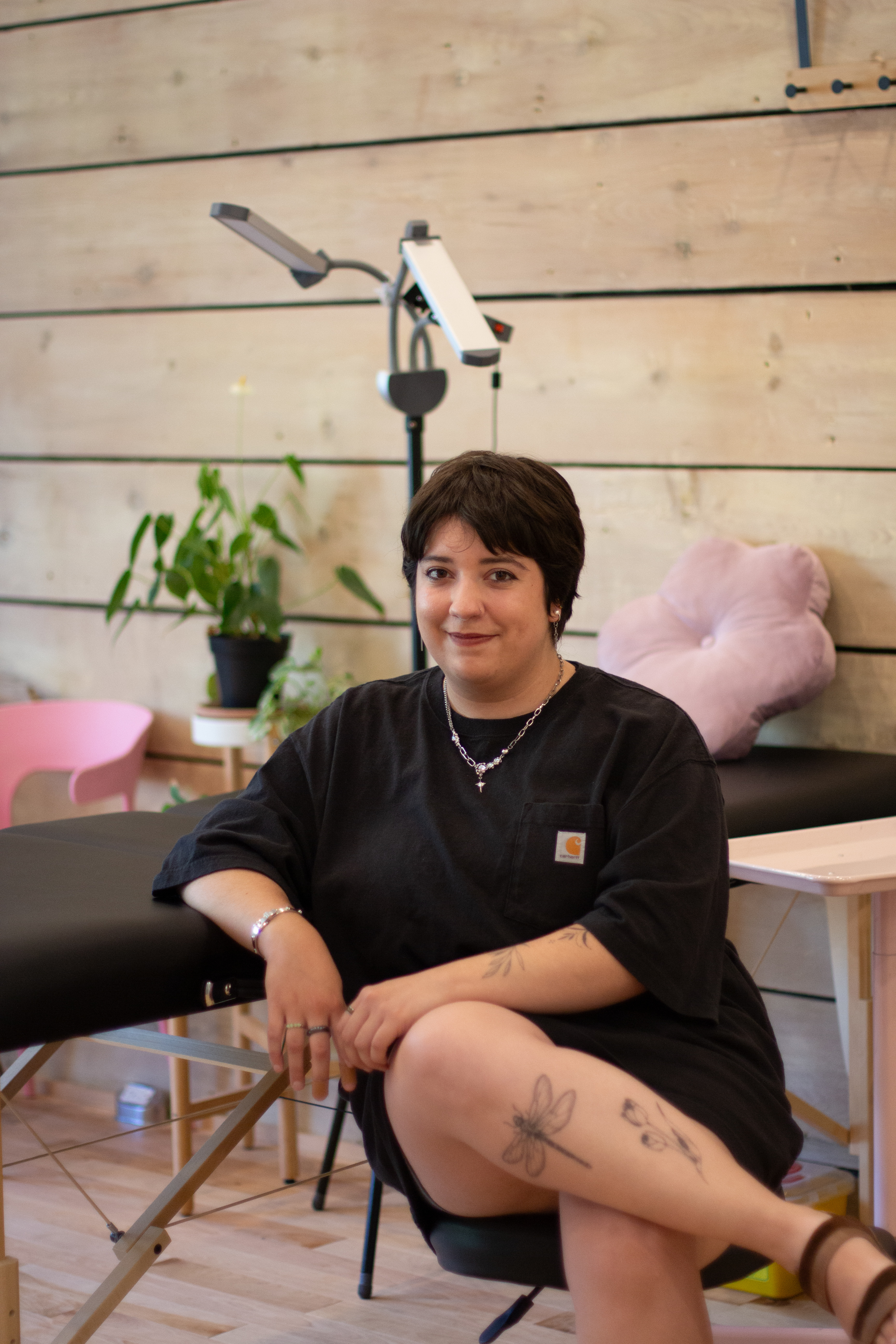 Rasa.tattoo artiste tatoueuse qui pose devant son espace de travail.
