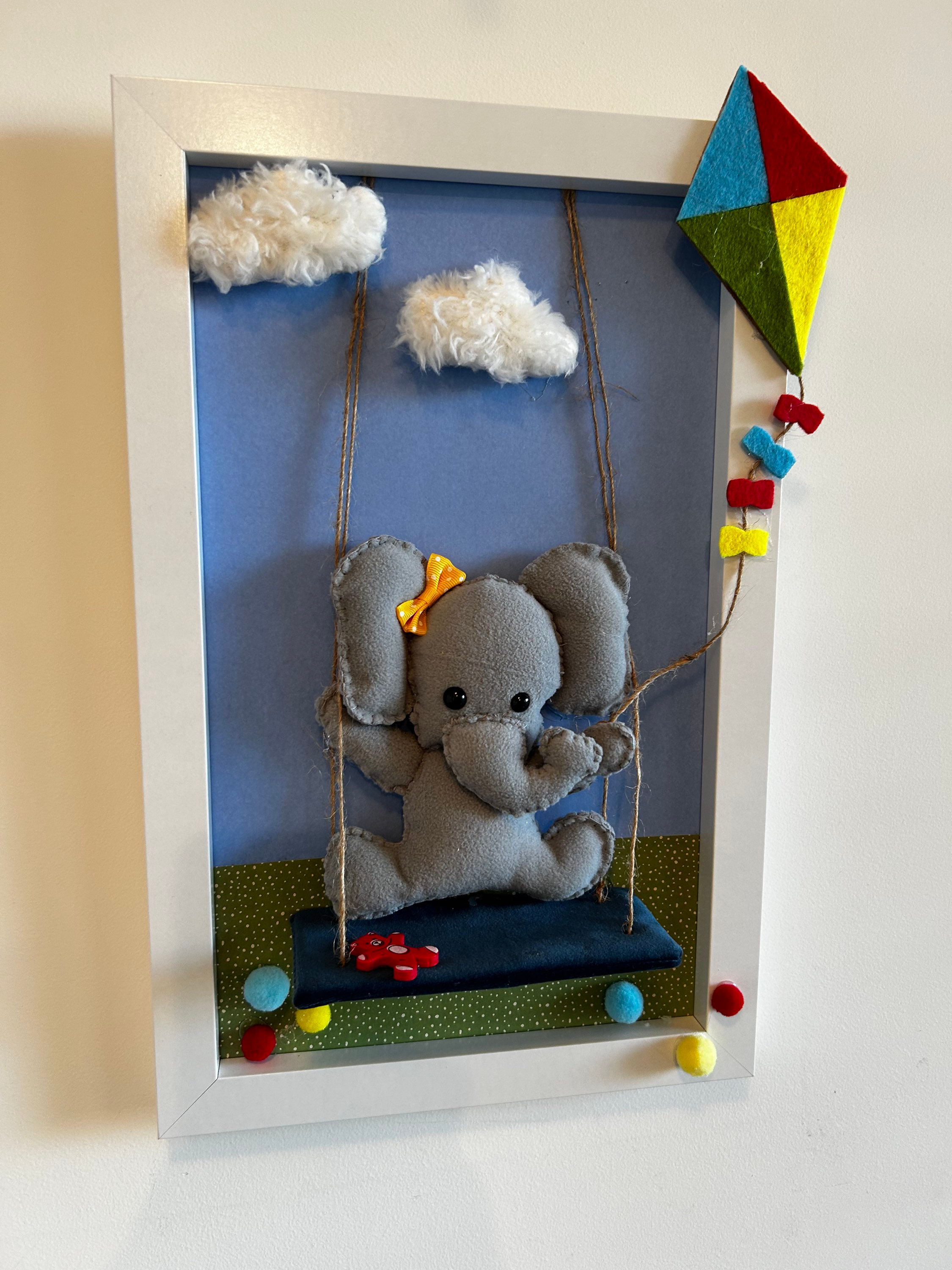 תמונה של פיל על נדנדה מחזיק עפיפון (1במלאי)