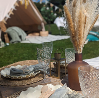 garden picnic table with pastel tones in a park with a bell tent on the background