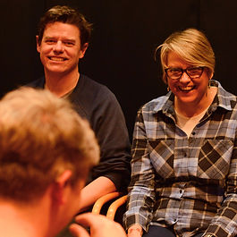 Participants smiling and listening during a theatre audition workshop.