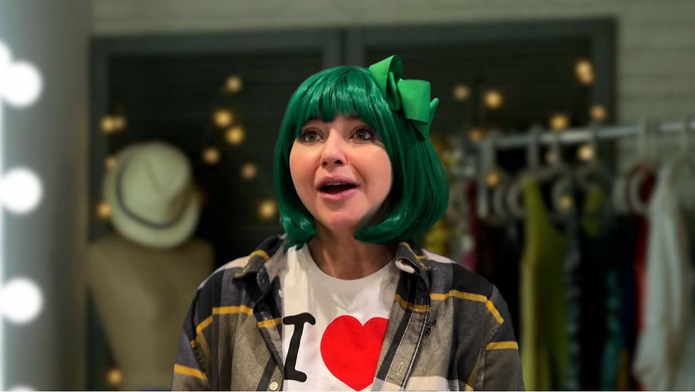 A young woman in a green wig sings into a mirror