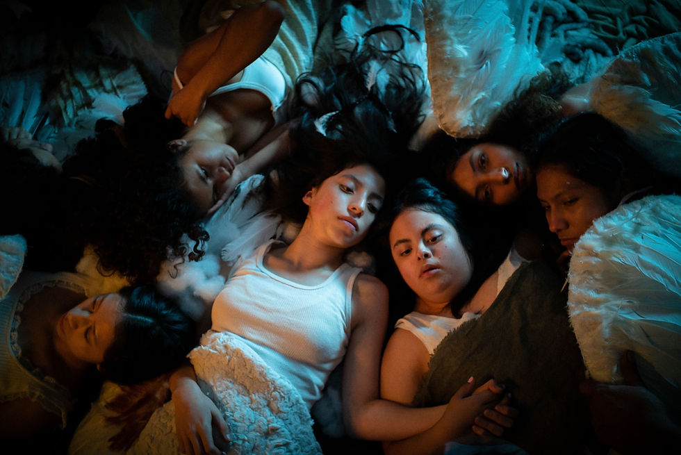 A group of girls in angel wings lay on the ground