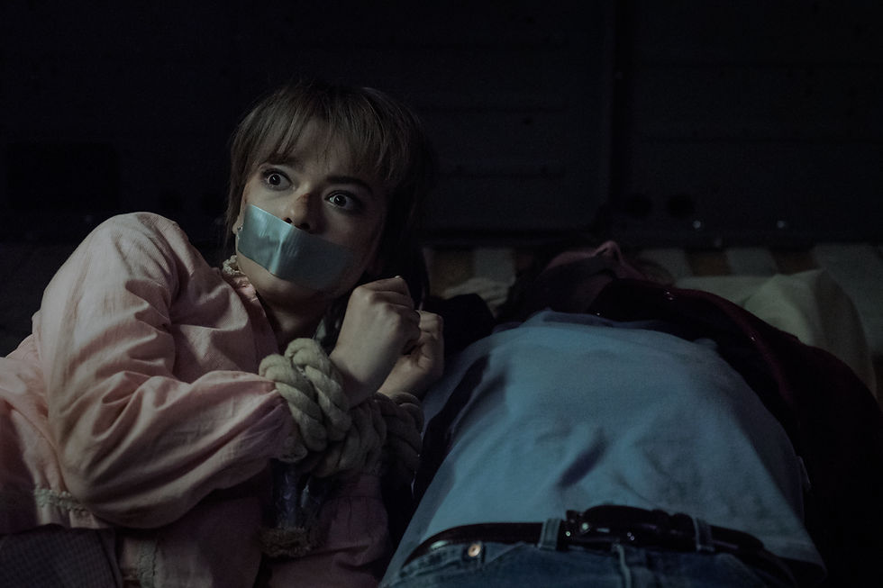 A woman is bound and has her mouth duct taped