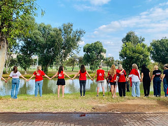 קבוצת נשים מחזיקות ידיים מסביב לאגם
