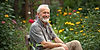 old man smiling in staisfaction sitting in a garden long short.jpg