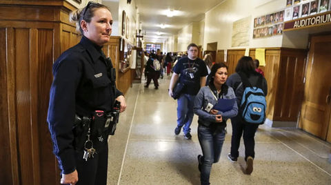 our mission and vision is the safety in schools A female, uniformed security guard in the passage of a school monitoring the students for school safety