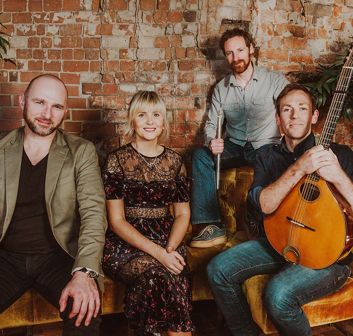 Described in the Journal of Music as “a thrilling new force in contemporary traditional music — fearless, cinematic, and crackling with raw energy” , Tempest are a powerful ensemble of traditional Irish musicians from Ulster. Featuring an exciting line-up of Brendan Mulholland, Blaithín Mhic Cana, Aaron O’ Hagan and Luke Ward, they have each achieved acclaim in their respective musical careers to date. Formed in 2023, Tempest are already regarded as a vibrant exponent of traditional Irish music and song, while their debut album, released in 2025, has received wide acclaim.
The group is firmly rooted in the heritage, song and music of their native Ulster and take great pride in sharing this with their audience. There is a particular focus on the singing tradition of Blaithín’s native South Armagh and wider Oriel region, while many of the tunes also take their origins from the northern province.
Brendan Mulholland is from Glenavy, on the shores on Lough Neagh, and is widely regarded as one of the finest exponents of the Irish wooden flute. As well as recording an extensive discography over the past two decades, he has also established on online music school where he teaches traditional Irish music to students all over the world.
Bláithín Mhic Cana is a Sean Nós singer and teacher, born and reared at the foot of Slieve Gullion County Armagh.
Mentored in her younger years by the acclaimed Sean Nós singer and researcher Padraigín Ní Uallacháin, Bláithín has a particular interest in the rich singing tradition of her home in South-East Ulster - a region once known as Oriel- and in the revival of these songs through practice, transmission and performance. She is passionate about language and community revival through the traditional arts, and divides her time between teaching, promoting arts and language in the community, and performing. She is also currently studying for an MA in the Traditional Arts and Irish in NUI, Maynooth.
Bláithín has won many awards for her singing, including several national awards at Oireachtas na Samhna and has been involved in many media productions as a singer and presenter for TG4 and the BBC.
In April 2024, Bláithín was awareded the Gradam Cois Life in Dublin for exceptional contribution to the tradition of singing in the Irish language.
Bláithín’s greatest passion is introducing the traditional songs and style of her own region, Oirialla, to a wide audience and in particular, to play a role in their revival and regeneration.
Aaron O’Hagan is a musician, teacher and maker of fine instruments, specialising in uilleann pipes and the traditional wooden flute. Born in Belfast, Aaron’s first introduction to traditional Irish music was through his grandfather James, learning his first notes on the tin whistle and getting a few tunes from him.
Aaron progressed onto the flute and later the pipes, learning from local musician Brendan Mulholland and Belfast piper Patrick O’Hare.
In the pursuit of quality instruments and the right sound, Aaron began to utilise his inherent love for the creative process and was motivated to embark on the journey into reed making and later into pipe and flute making, taking Inspiration from past masters such as Leo Rowsome, The Crowleys, Ruddal & Rose and Prattens. Aaron has taught instrument and reed making workshops at Na Píobairí Uilleann in Dublin and at many festivals around the world. Aaron plays all his own instruments on the debut Tempest album.
In 2021, Aaron released the critically acclaimed ‘From the Devil’s Punchbowl’ with bouzouki player, Luke Ward. Aaron is also a prolific teacher and passes on his knowledge at the award winning Glengormley School of Traditional Music.
Competing the lineup is Cavan’s own Luke Ward who has been a constant on the traditional music circuit since the 2005 release of ‘Clan Ranald’ with accordionist Martin Tourish. Over the past 20 years he has performed all over the world from the Shetland Islands to Las Vegas. After starting his musical career as a fiddle player, he soon transitioned onto guitar, bouzouki and cittern, and is most comfortable acting as the rhythm section in traditional and folk music.
Luke particularly enjoys the recording process and engineered the aforementioned ‘From the Devil’s Punchbowl’ album with O’Hagan. Similarly to his bandmates, Luke places a strong value on teaching traditional music and does this mostly through his online bouzouki school.