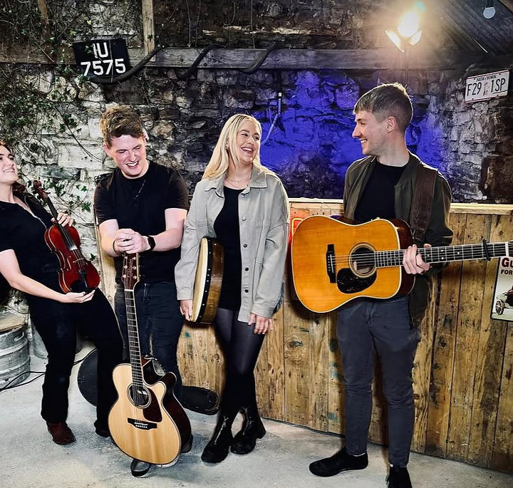 Folk Division is a vibrant group of young singers and multi-instrumentalists from Galway, in the heart of the West of Ireland. Formed through a shared passion for folk music and live performance, the group quickly gained momentum. Within a short time, they were performing in leading venues across Ireland, attracting a growing following and receiving multiple invitations to perform internationally. They have recorded several tracks in the studio and have maintained a demanding live schedule over the past number of years.
The group features Thomas Ryan (whistle/guitar), who has toured internationally with a well-established traditional Irish act, and Aaron Killilea (guitar/vocals), an experienced performer abroad and frontman of a popular wedding band. Chloe Reilly is the band’s lead female vocalist and a highly regarded performer on the Irish wedding circuit. Completing the lineup is Ella Partington, a skilled session musician from Brighton whose versatility brings a distinctive dimension to the group’s sound. All four members are accomplished multi-instrumentalists, contributing to the band’s rich and varied arrangements.
Folk Division blends the timelessness of traditional Irish music with fresh, contemporary arrangements, offering audiences a vibrant experience. Their performances are marked by musicality, authenticity, and a shared enthusiasm that resonates with listeners of all ages.