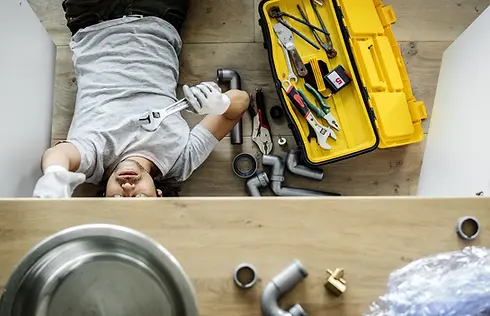 Man fixing kitchen sink.webp
