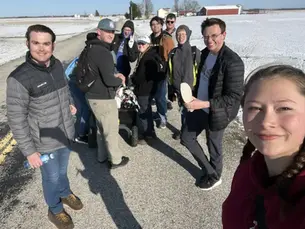 A group of NDP participants pose together on a snow-covered country road during the Carthage Walk