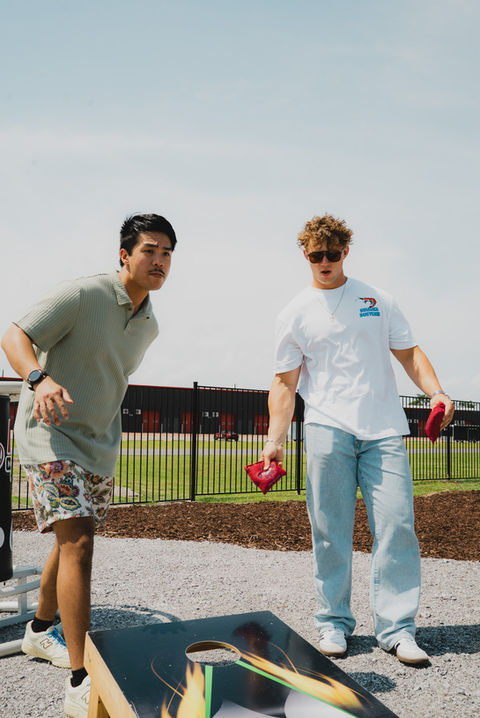 Friends playing cornhole outdoors.
