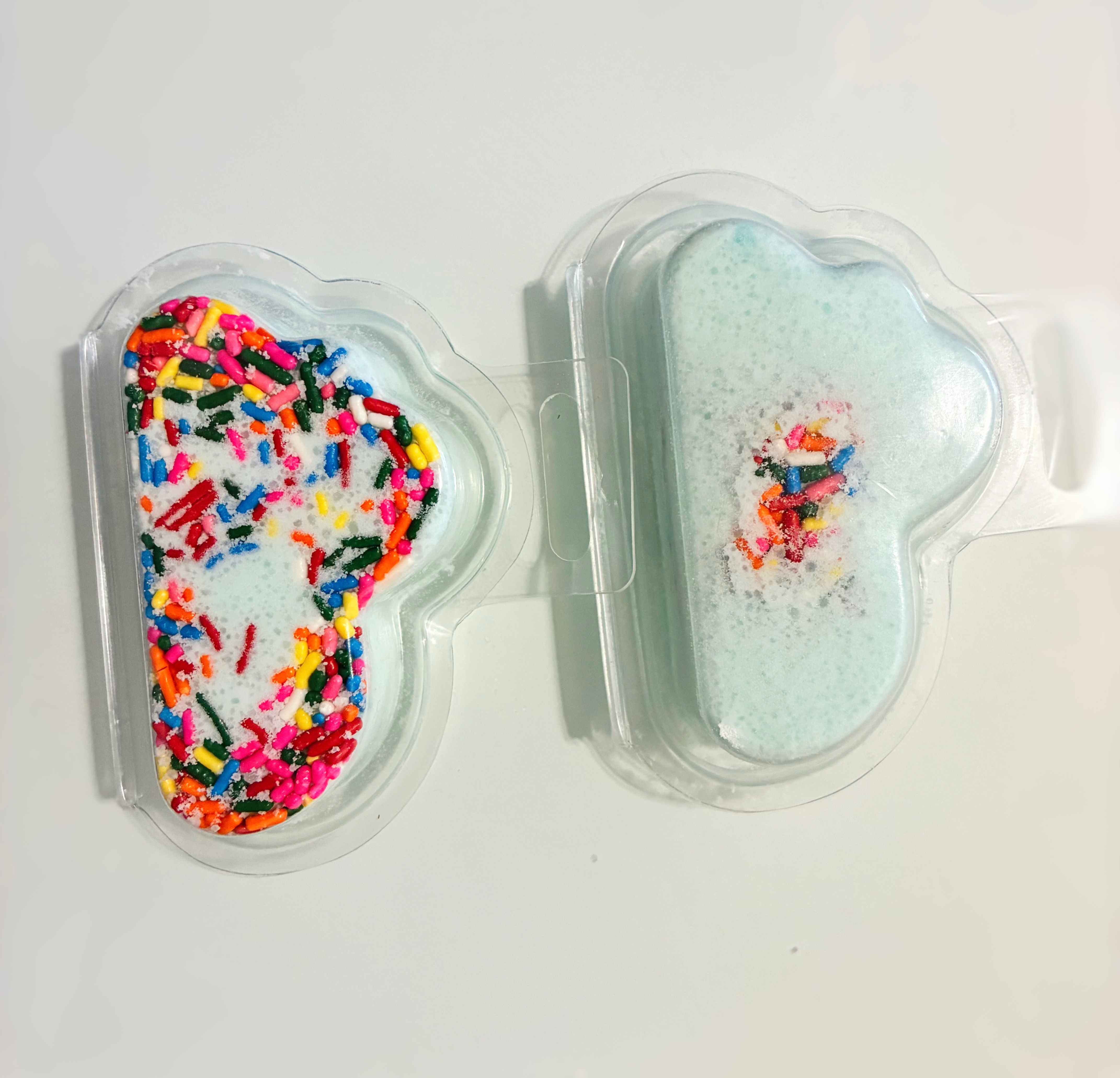Cloud-shaped bath bombs with sprinkles. Vanilla Cake Bath Bombs and bath bomb in packaging.